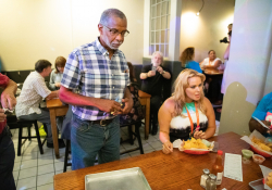 July 12, 2019: — Senator Art Haywood and and fellow legislators serve up food, coffee and drinks to customers during the busy happy hour at El Fuego restaurant in support of the federal Raise the Wage Act nationwide and One Fair Wage in the state.